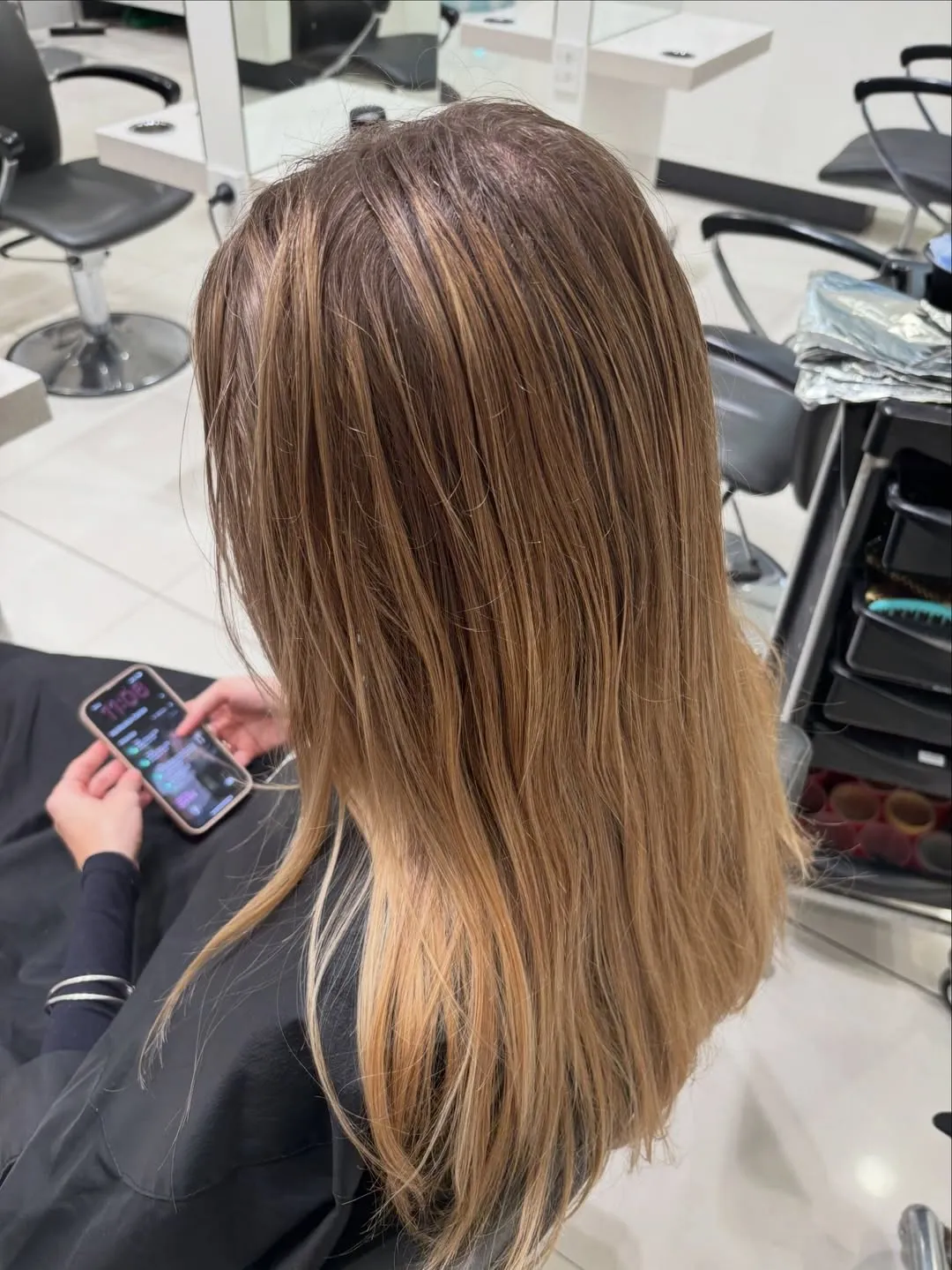Before - long hair with grown-out roots and uneven warm blonde ends, ahead of a blonde colour transformation at Characters Hair Randwick