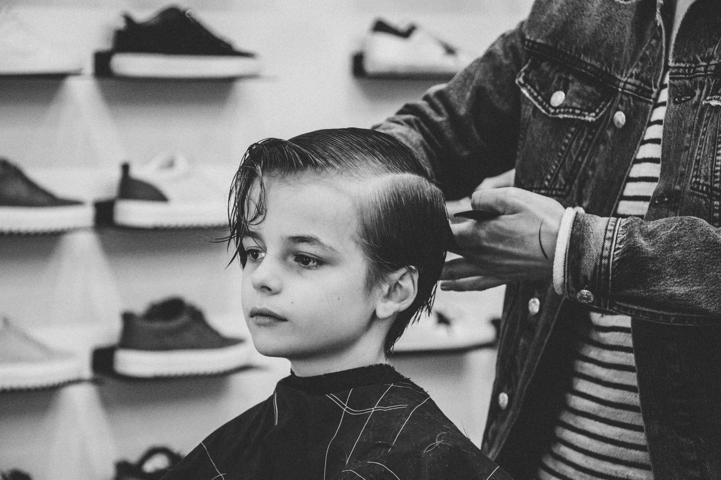 Stylist combing through a young boy's hair during a children's haircut at Characters Hair, Randwick, Eastern Suburbs Sydney
