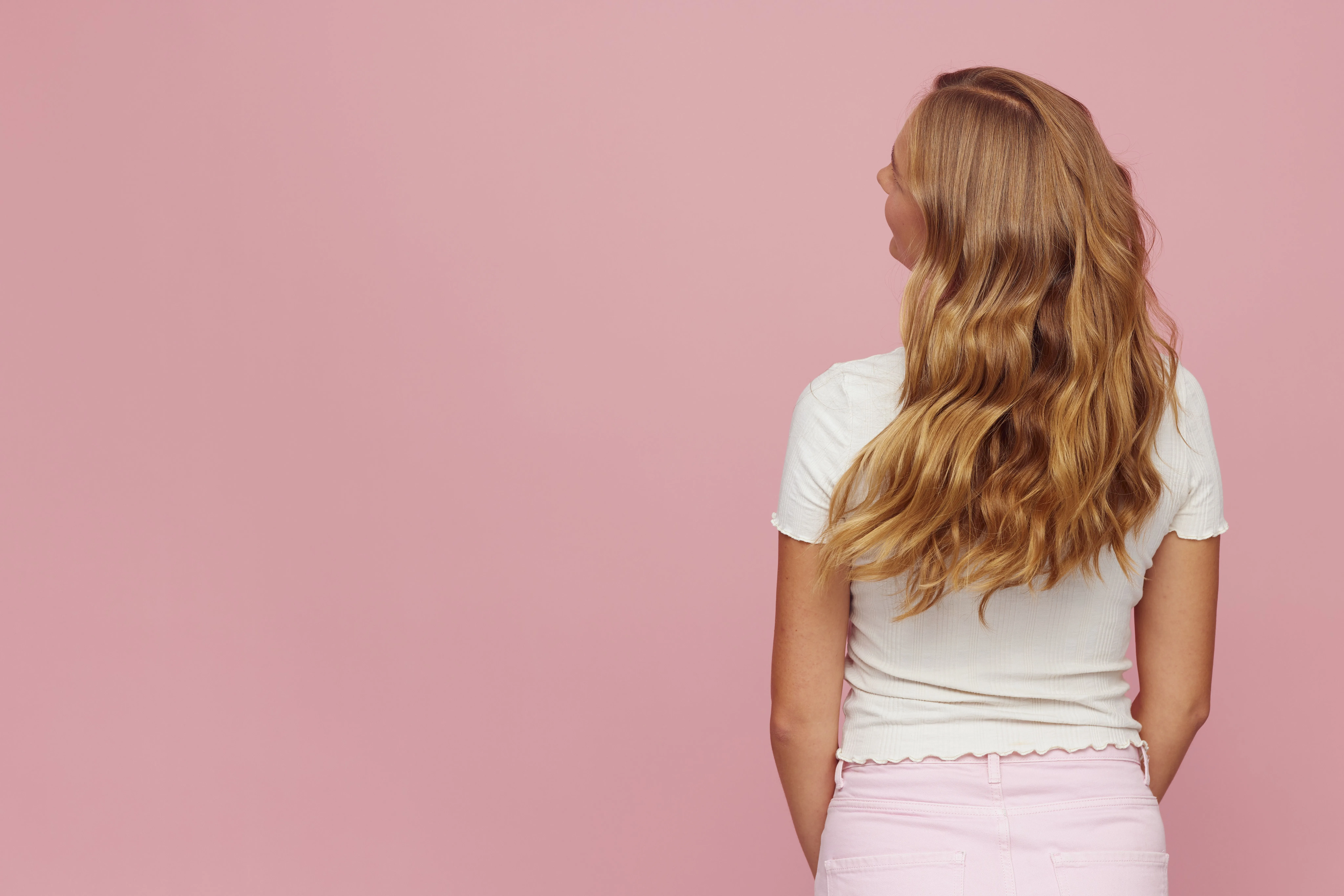 Back view of long wavy golden blonde hair kept fresh with toning and glossing - blonde refresh and maintenance at Characters Hair, Randwick, Eastern Suburbs Sydney